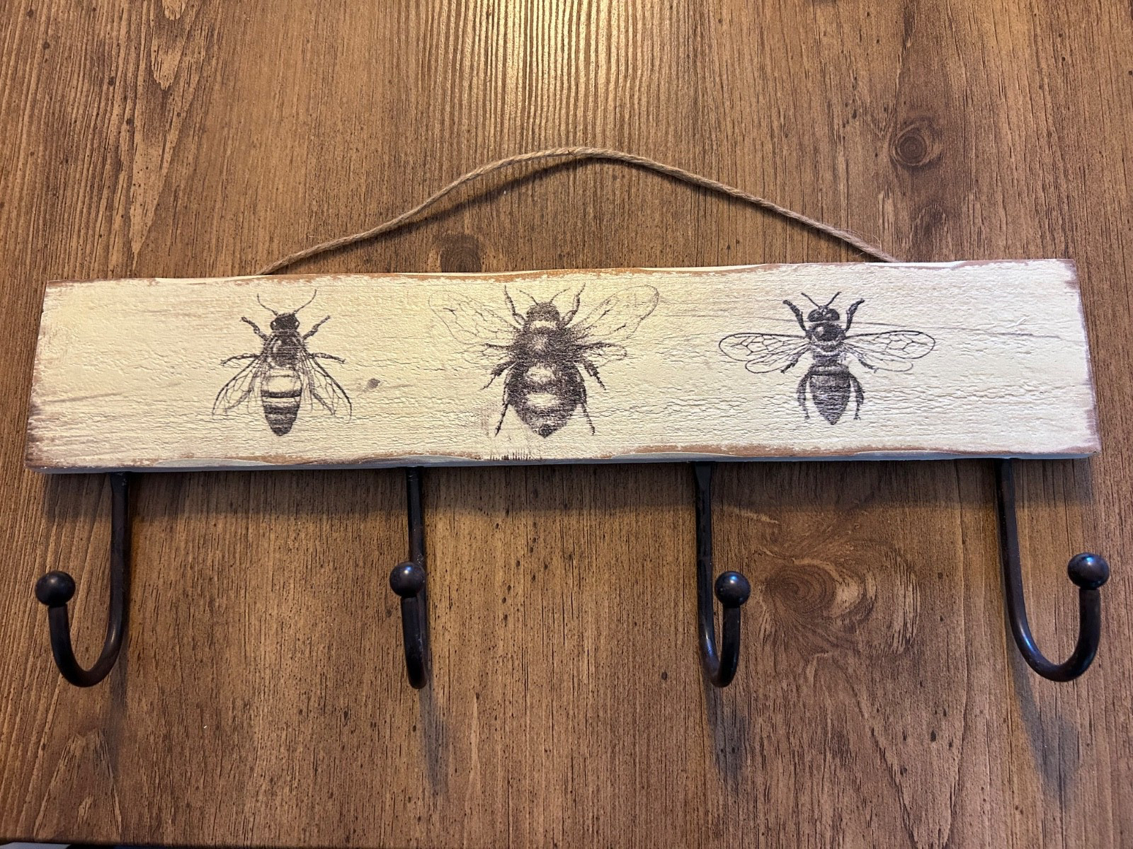 16” wooden black and cream colored bee motif wall plaque with coat hooks